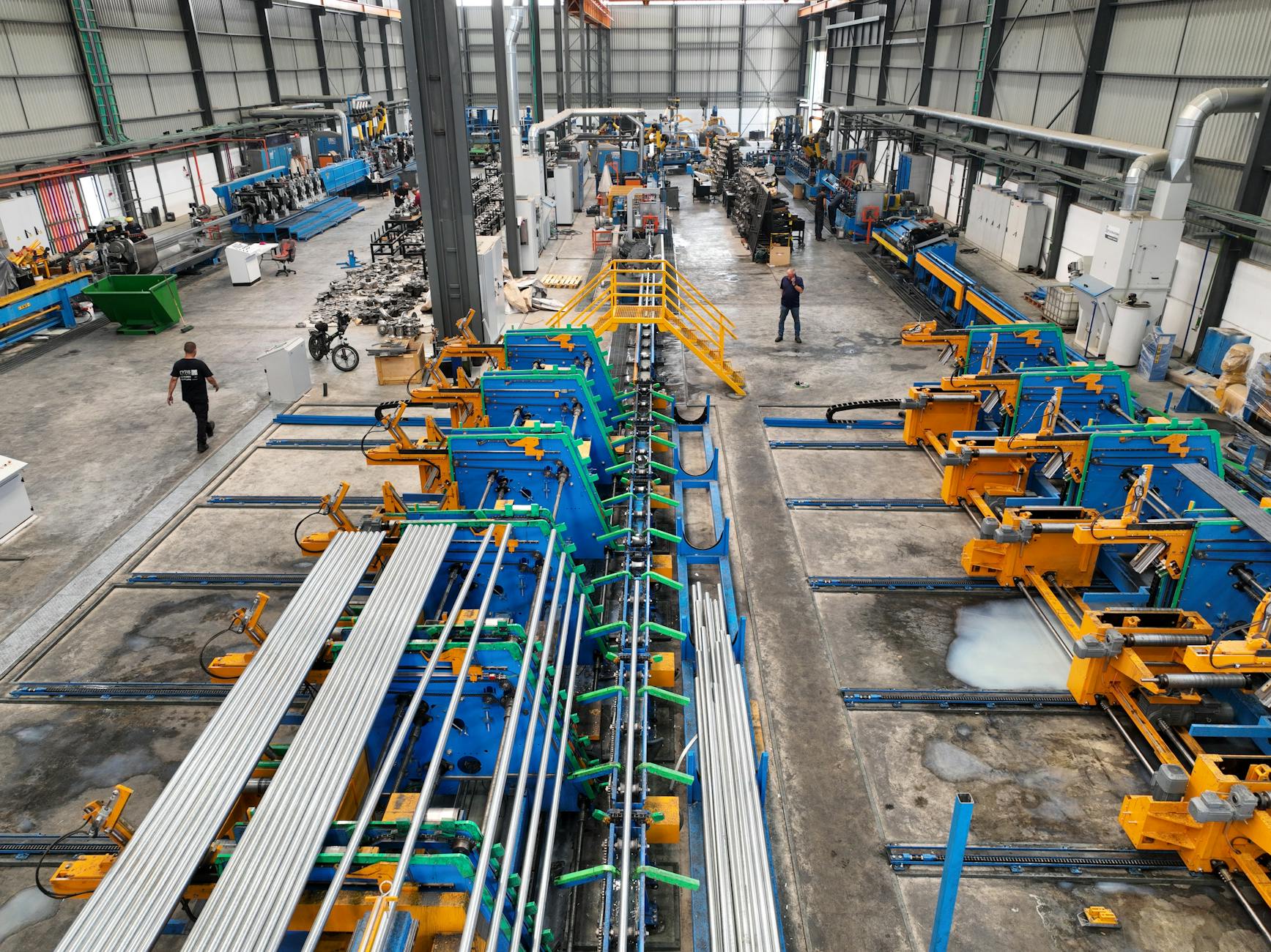 Aerial view of a large manufacturing plant interior with machinery and workers.