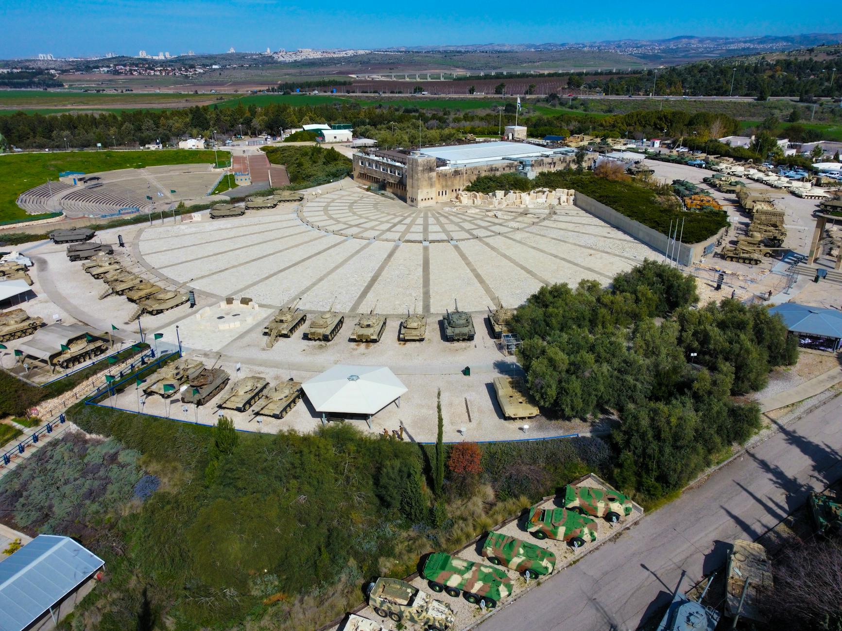 An aerial view of the Yad La-Shiryon Memorial in Israel featuring tanks and a circular plaza.