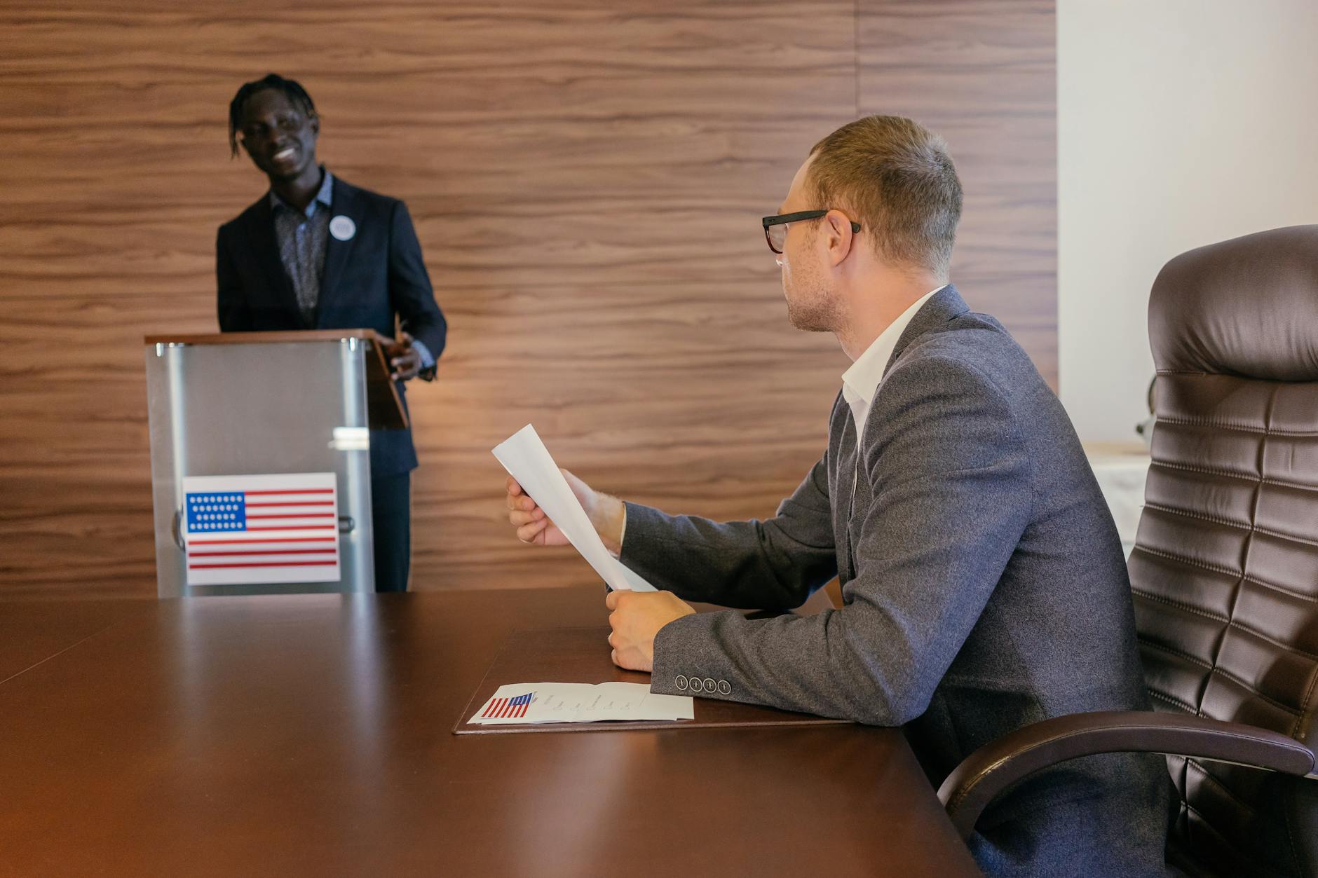 Two professionals in discussion during a political meeting in a modern conference room.